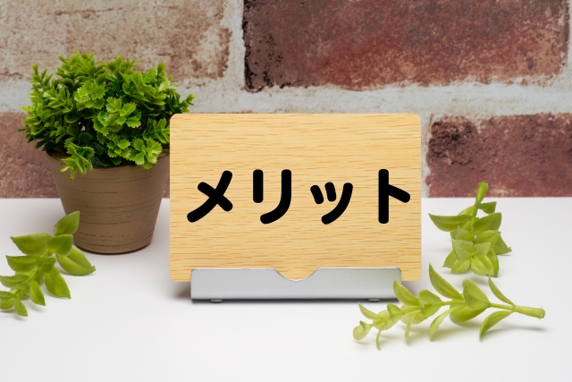 木目のメッセージボードにメリットの文字