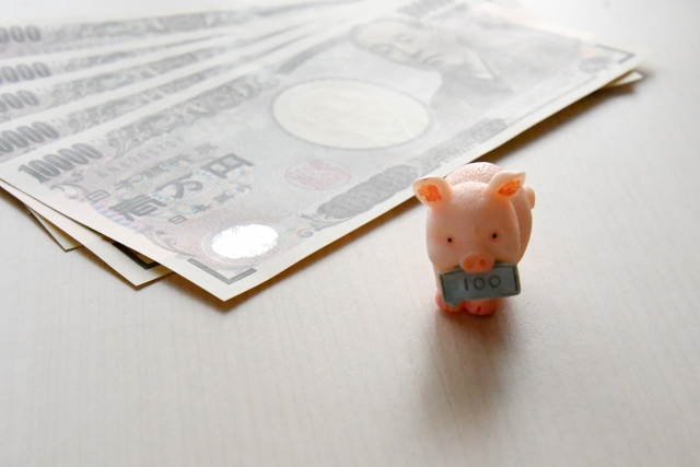 1万円札5枚と豚の人形