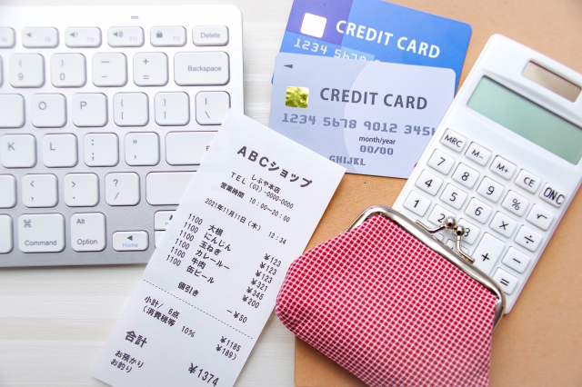 パソコンキーボードとクレジットカード、電卓、レシート、財布