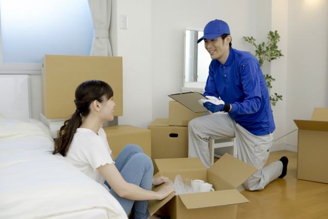 荷造りする女性と、引越し業者