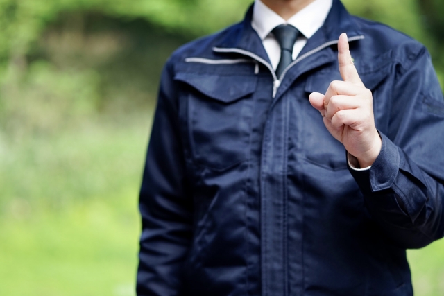 人差し指を立てて注意を促す男性
