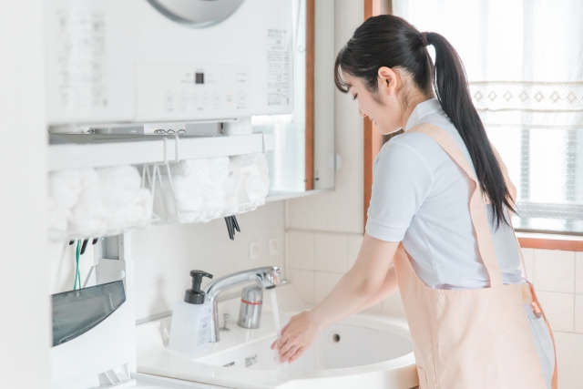 台所で手を洗うハウスクリーニングの女性スタッフ
