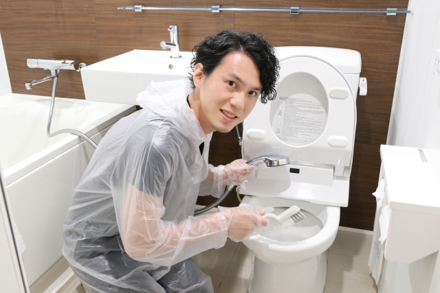 トイレ掃除をする作業員