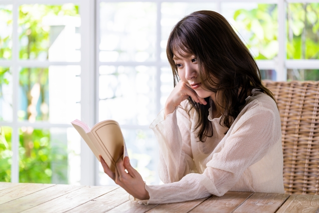 家でまったり本を読む女性